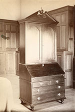 Tall writing desk with slant top, drawers, and cabinet.